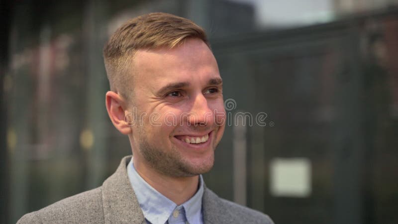 En positiv ung man i kavaj som pockar i staden. långsam rörelse arkivfoton