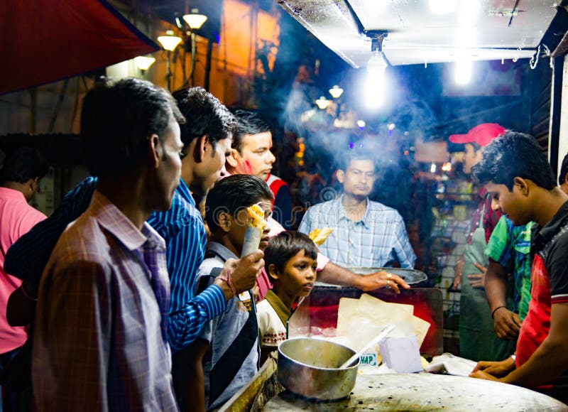 En septiembre de 2017, Kolkata, la India Clientes que compran rollo de huevo en una parada en kolkata en la noche foto de archivo libre de regalías En septiembre de 2017, Kolkata, la India Clientes que compran rollo de huevo en una parada en kolkata en la noche foto de archivo libre de regalías