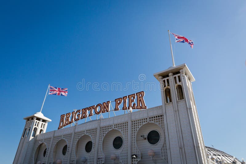 En signage av Brighton Pier med den engelska flaggan royaltyfri bild En signage av Brighton Pier med den engelska flaggan royaltyfri bild