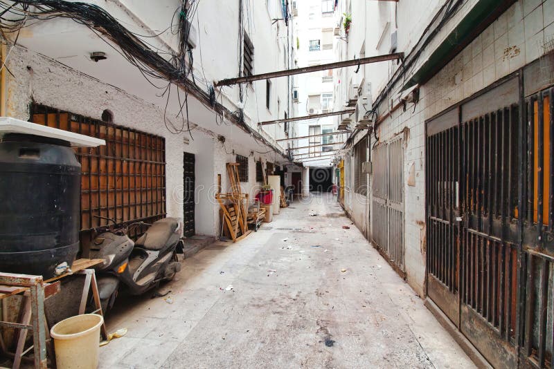 San Juan, Sevilla, Spain - June 11 2022: A narrow alley with high walls in a poor, marginalized part of downtown. San Juan, Sevilla, Spain - June 11 2022: A narrow alley with high walls in a poor, marginalized part of downtown