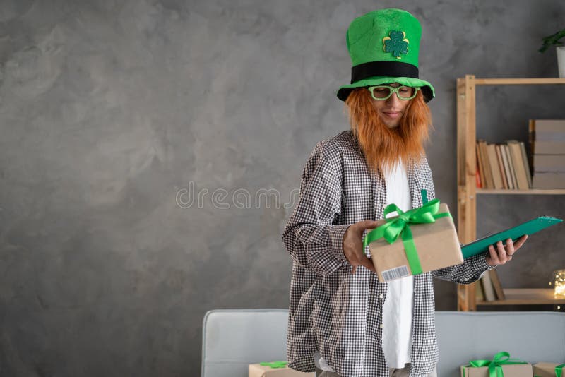 En småföretagare med en leprechaun som förbereder en låda för leverans när han eller hon arbetar från sitt hemkontor fotografering för bildbyråer