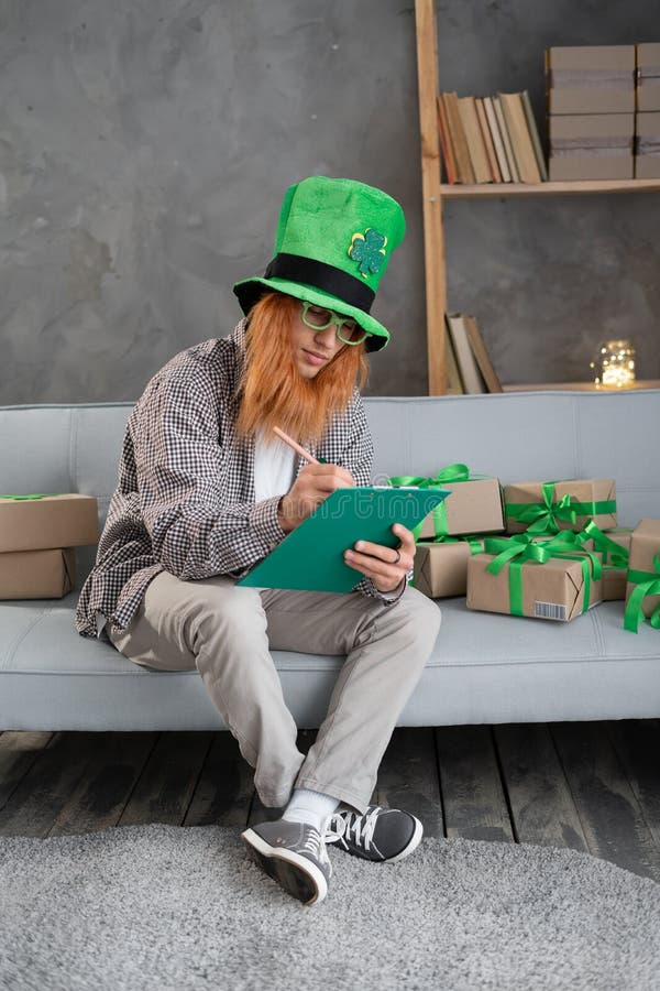 En småföretagsägare i en leprechaun som förbereder en låda för frakt på st. patriarkdag. royaltyfria foton