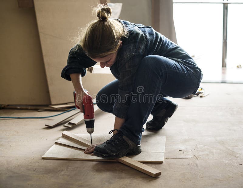 En snickare som använder en drillborr på ett trä arkivfoto En snickare som använder en drillborr på ett trä arkivfoto