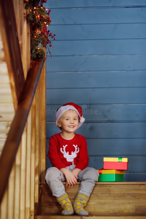 En speciell liten pojke med julklapp på trapphus Porträtt av lycklig unge på julmorgon arkivbilder