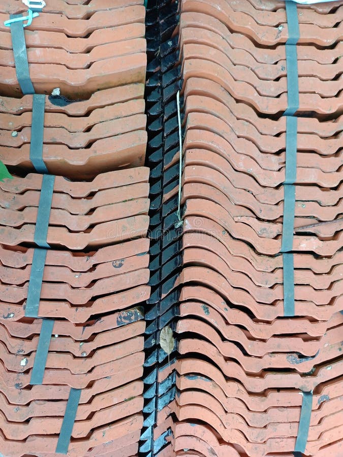 A pile of house tiles, piled up behind a residential house, taken at a high angle. A pile of house tiles, piled up behind a residential house, taken at a high angle