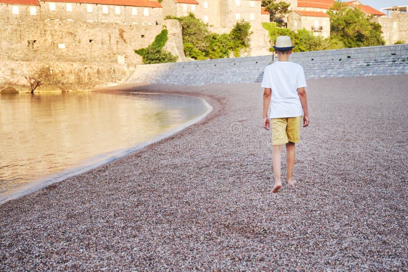 En stilig tonårspojke på kusten. begreppet sommarsemester och sommarresor. fotografering för bildbyråer