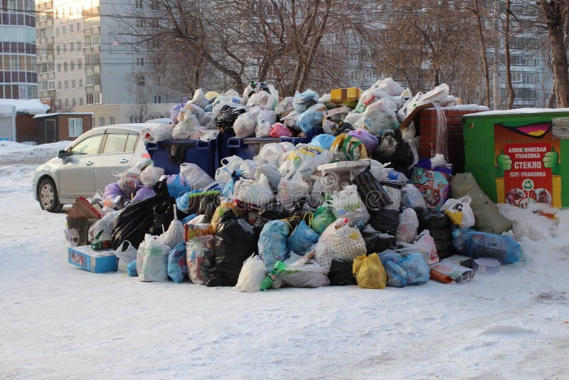 En stor hög av plastpåsar av avskräde- och hushållavfalls i stadsförrådsplatsen i vintern i Novosibirsk förorenar miljön arkivfoto En stor hög av plastpåsar av avskräde- och hushållavfalls i stadsförrådsplatsen i vintern i Novosibirsk förorenar miljön arkivfoto