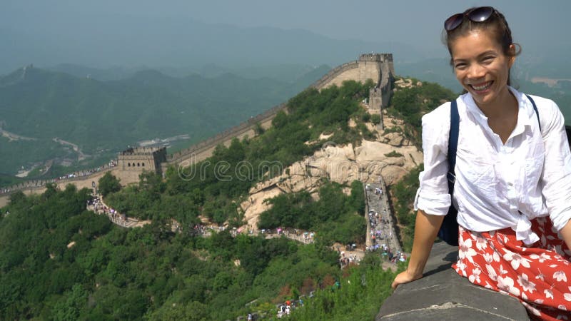 En stor vägg av kinesisk turister på resande hand som hälsar på badning
