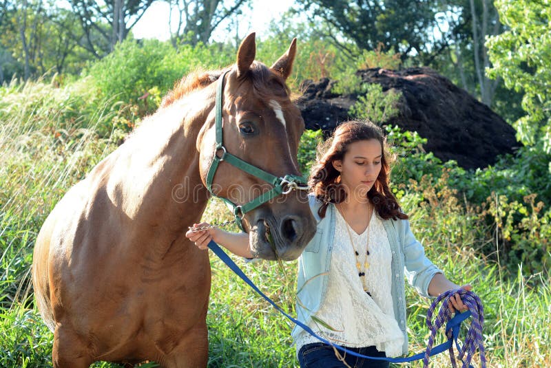 En tonårsflicka går med sin häst royaltyfri foto