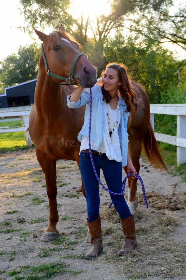 En tonårig flicka går med hennes häst arkivbild