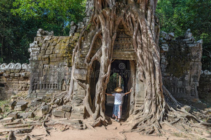 En turist- besöka Angkor fördärvar under djungeln, det Angkor Wat tempelkomplexet, loppdestinationen Cambodja Kvinna med den trad fotografering för bildbyråer En turist- besöka Angkor fördärvar under djungeln, det Angkor Wat tempelkomplexet, loppdestinationen Cambodja Kvinna med den trad fotografering för bildbyråer