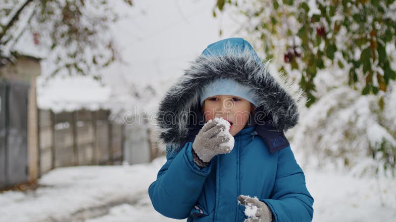 En una ciudad nevada un niño fuerte lucha la ventisca abriéndose paso por un camino a través del difícil clima invernal
