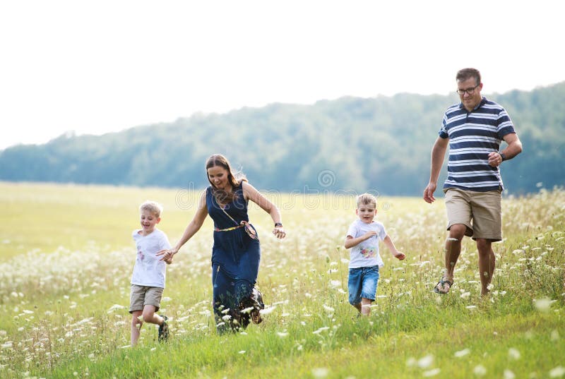 En ung familj med två lilla söner som går i natur på en sommardag arkivfoton En ung familj med två lilla söner som går i natur på en sommardag arkivfoton