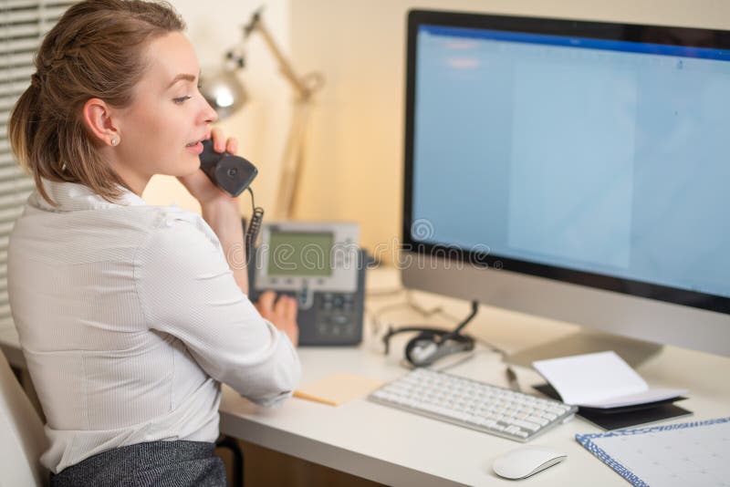 En ung flicka arbetar i en appellmitt För en arbetsplats med en telefon En mikrofon med en mikrofon serviceservice f?r illustrati royaltyfri foto En ung flicka arbetar i en appellmitt För en arbetsplats med en telefon En mikrofon med en mikrofon serviceservice f?r illustrati royaltyfri foto