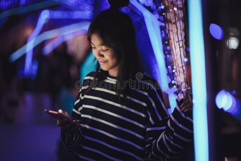 En ung flicka som använder en mobiltelefon i centrala städer