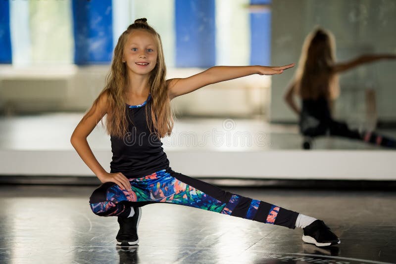 En ung flickgymnast i en svart leotard ser ut mot kameran Flickdans moderna koreografi Hip Hop Girl royaltyfria foton