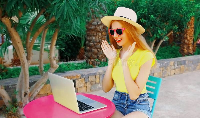 En ung kvinna som arbetar med en bärbar dator medan hon sitter vid bordet på sommarsemestern