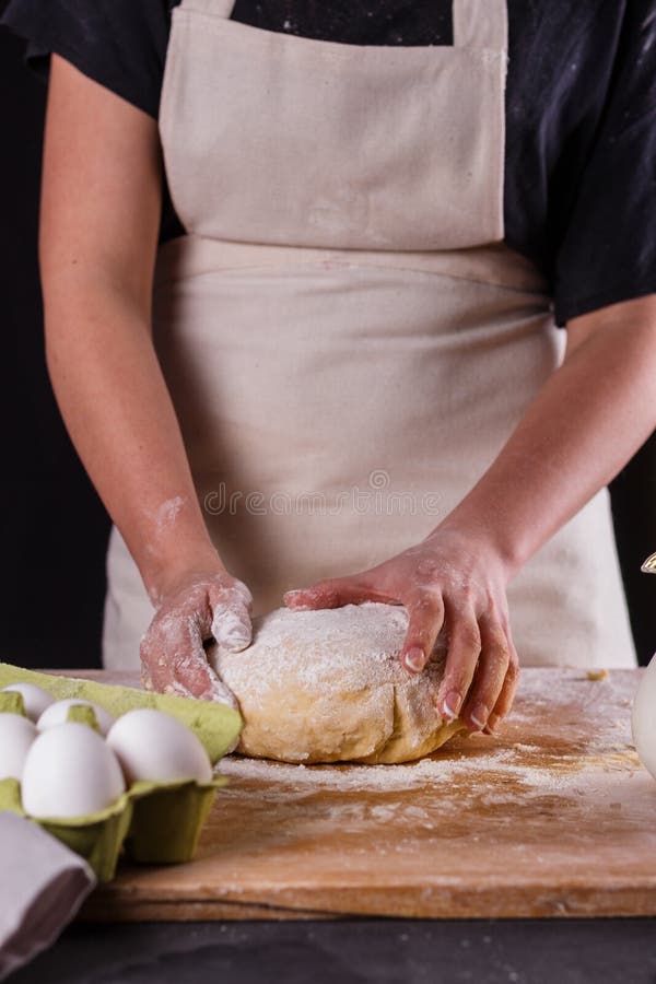 En ung kvinna som bär en anka på en träbräda i en apron royaltyfri foto