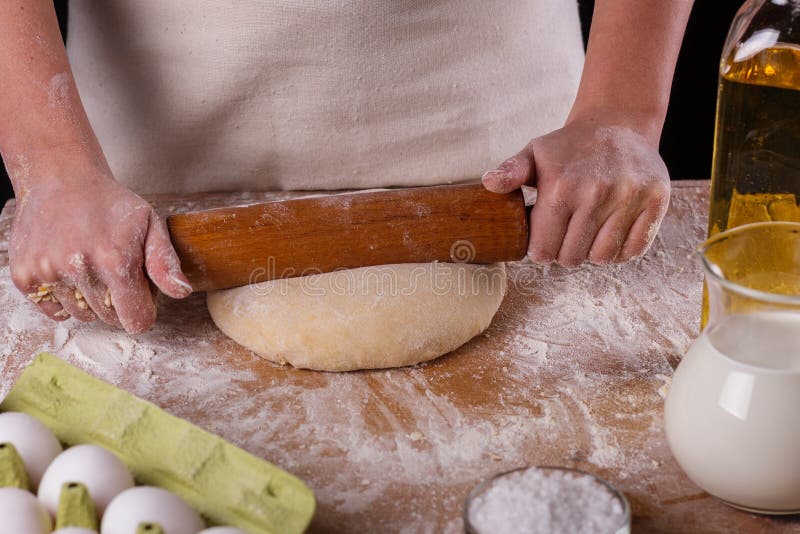 En ung kvinna som bär en anka på en träbräda i en apron arkivfoto