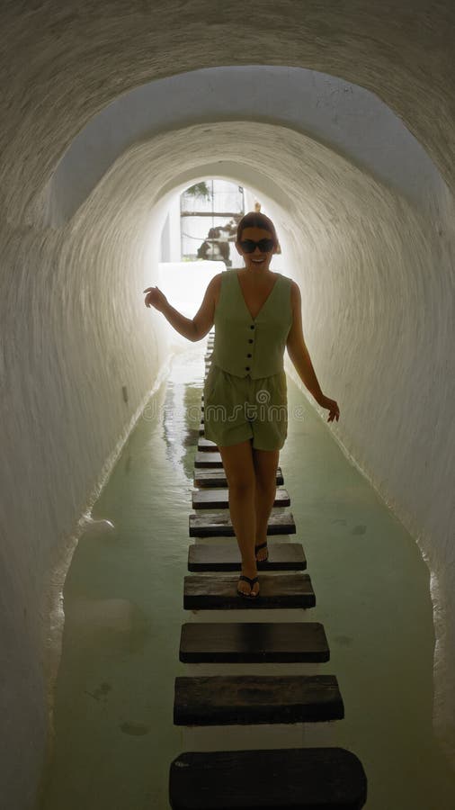 En ung kvinna som går i en tunnel med stenstenar på kanarieöarna i lagomar lanzarote en soldag royaltyfria bilder