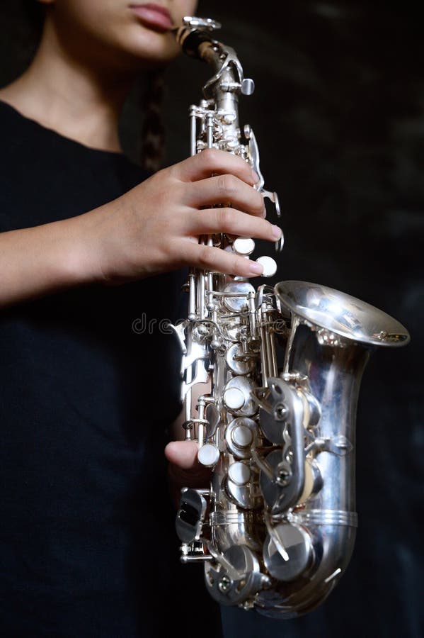 En ung musiker som spelar en silversaxofon royaltyfri foto