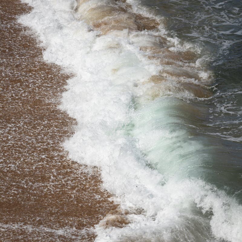 En våg från havsolyckor till sand på stranden i Australien royaltyfri fotografi