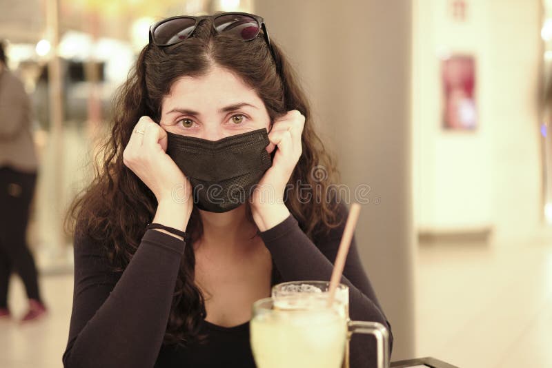 En 35-årig kvinna med ansiktsmask under svåra pandemiska år i små royaltyfri fotografi