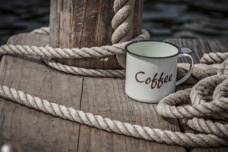 https://thumbs.dreamstime.com/b/enamel-coffee-mug-rope-rustic-cup-word-decorative-thick-wooden-jetty-water-s-edge-137340795.jpg
