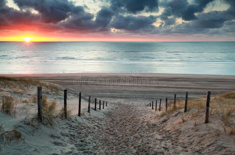 Enarene la trayectoria a la playa de Mar del Norte en la puesta del sol fotografía de archivo Enarene la trayectoria a la playa de Mar del Norte en la puesta del sol fotografía de archivo