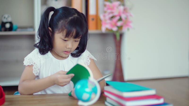 Encantadora chica leyendo un libro y comiendo galleta
