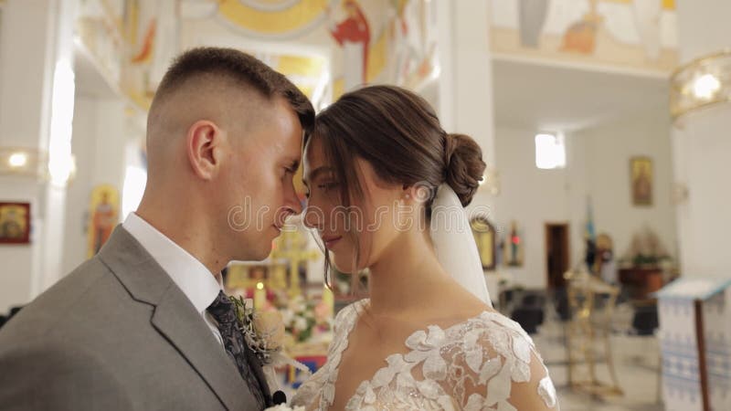 Encantadora familia recién casados pareja novia abrazando novio en una antigua ceremonia de boda de la iglesia matrimonio