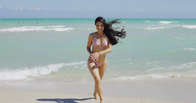 Encante a la muchacha bikini que camina en la playa