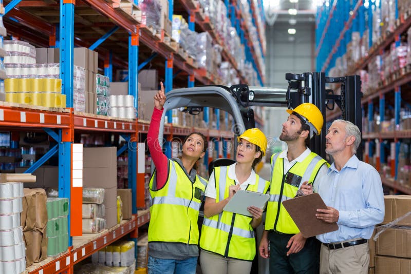 Encargado y compañeros de trabajo de Warehouse que discuten sobre el tablero fotos de archivo libres de regalías Encargado y compañeros de trabajo de Warehouse que discuten sobre el tablero fotos de archivo libres de regalías