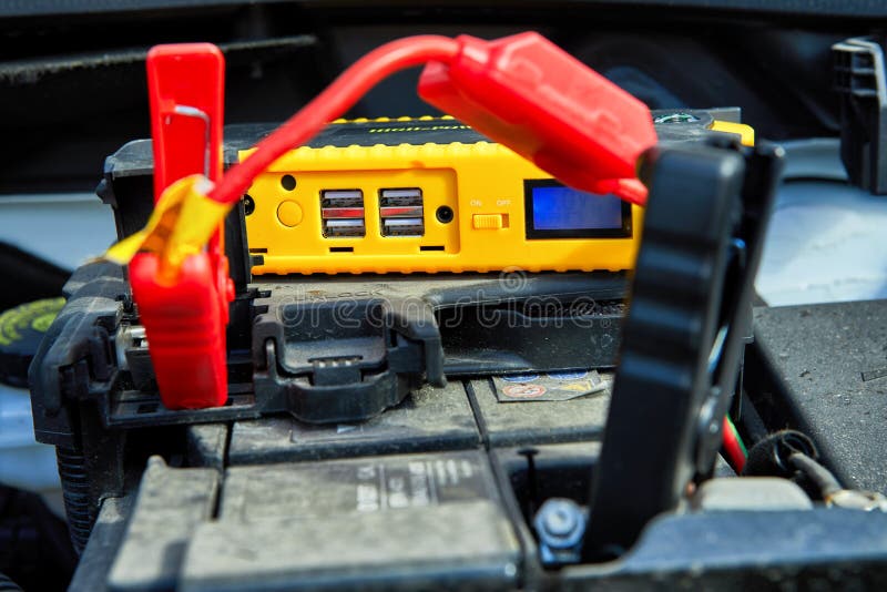 encargar un coche de electricidad a trav?s de los cables de una bater?a compacta foto de archivo libre de regalías encargar un coche de electricidad a trav?s de los cables de una bater?a compacta foto de archivo libre de regalías