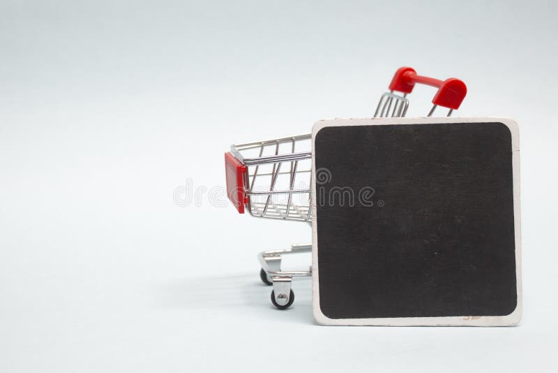 Encerramento do carrinho de compras com o quadro preto de giz em forma de meia-pancada sobre fundo leve fotos de stock Encerramento do carrinho de compras com o quadro preto de giz em forma de meia-pancada sobre fundo leve fotos de stock