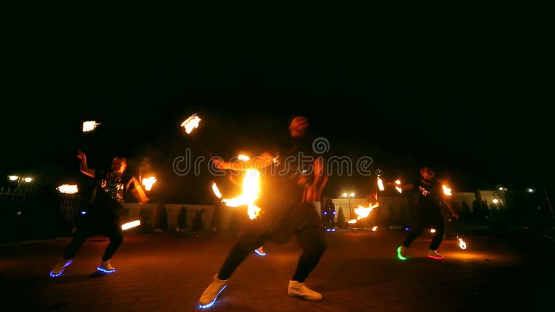 Encienda la demostración Un grupo de artistas profesionales realiza una variedad de instalaciones del fuego Los muchachos y las m