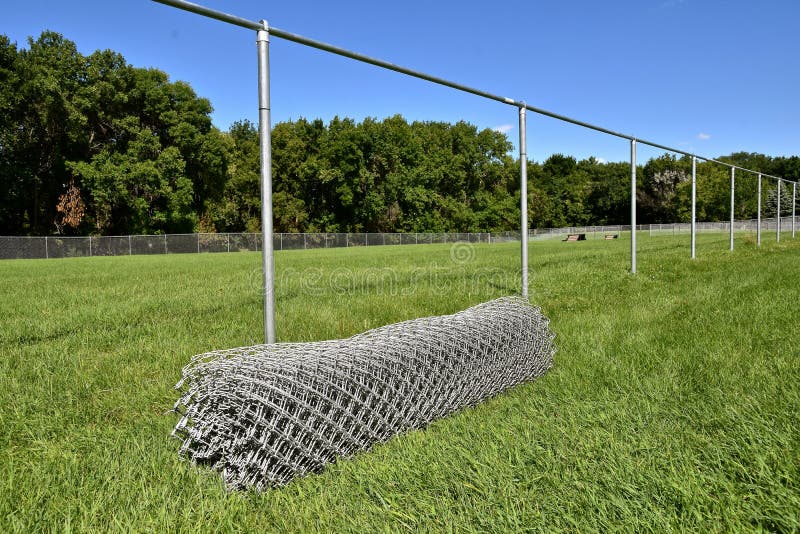 A roll of steel mesh is the last step of installment on a metal fence
