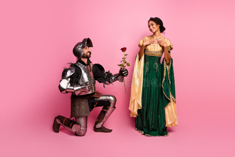 Encuentro romántico de un caballero y una princesa con trajes medievales de fondo rosado fotos de archivo libres de regalías
