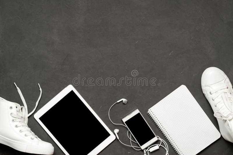 Endecha plana de las zapatillas de deporte blancas de la moda en fondo negro con el teléfono, auriculares, tableta, libro de la c imágenes de archivo libres de regalías Endecha plana de las zapatillas de deporte blancas de la moda en fondo negro con el teléfono, auriculares, tableta, libro de la c imágenes de archivo libres de regalías
