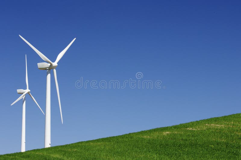 Two windmills in a green meadow with blue sky. Two windmills in a green meadow with blue sky