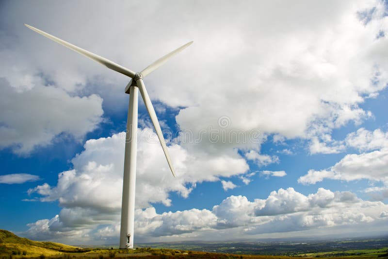 Wind turbine on the green grass over the deep blue clouded sky. Wind turbine on the green grass over the deep blue clouded sky