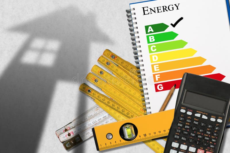 Energy efficiency rating graph in a notebook with a shadows of a house, calculator, wooden folding rulers, spirit level and a pencil. Energy efficiency rating graph in a notebook with a shadows of a house, calculator, wooden folding rulers, spirit level and a pencil