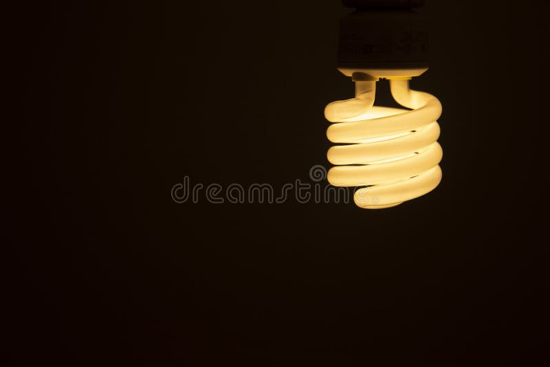 Energy Efficient Fluorescent Glowing Light Bulb on Dark Background