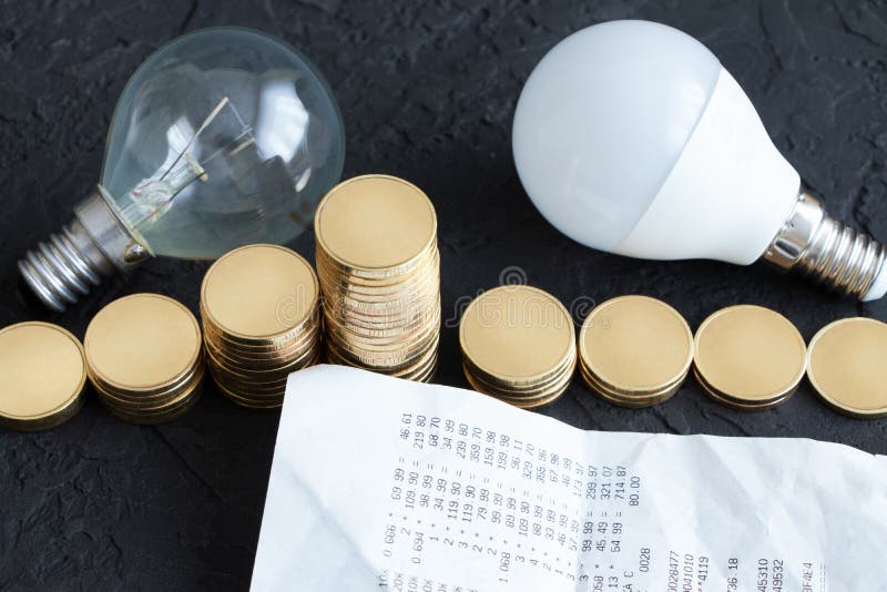 Energy Saving. Energy Saving Light Bulb and Old Bulb.Money Coins on a