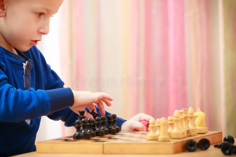 Enfance. Enfant intelligent d'enfant de garçon jouant des échecs. À la maison. image stock Enfance. Enfant intelligent d'enfant de garçon jouant des échecs. À la maison. image stock
