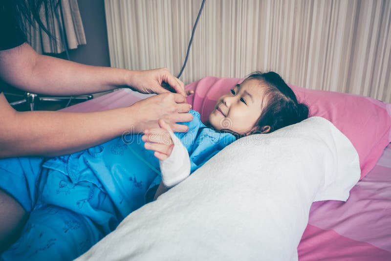 Enfant asiatique admis dans l'hôpital avec l'égouttement intraveineux salin dessus photographie stock Enfant asiatique admis dans l'hôpital avec l'égouttement intraveineux salin dessus photographie stock