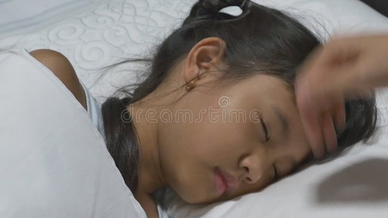 Enfant asiatique malade et dormant sur le lit