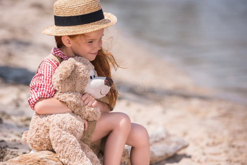 Enfant avec l'ours de nounours au bord de la mer images stock Enfant avec l'ours de nounours au bord de la mer images stock