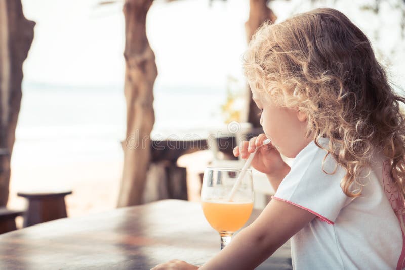 Enfant buvant le mode de vie de déplacement d'enfance de vacances de vacances d'été de plage de jus d'orange images libres de droits Enfant buvant le mode de vie de déplacement d'enfance de vacances de vacances d'été de plage de jus d'orange images libres de droits