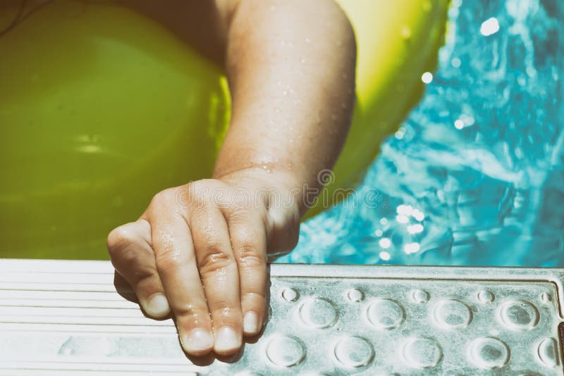 Enfant d'enfant en bas âge se tenant sur l'échelle dans la piscine extérieure sur a photo libre de droits Enfant d'enfant en bas âge se tenant sur l'échelle dans la piscine extérieure sur a photo libre de droits